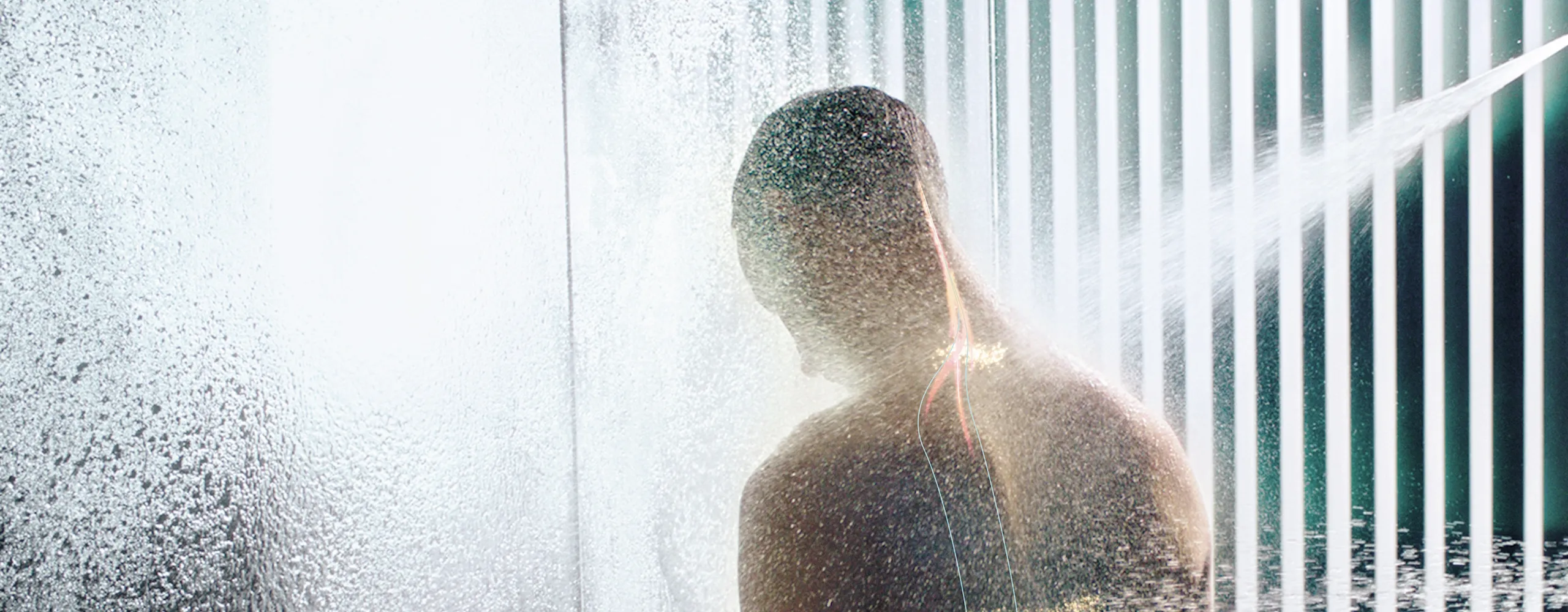 Mann genießt Aquapressur mit Regendusche von Dornbracht.