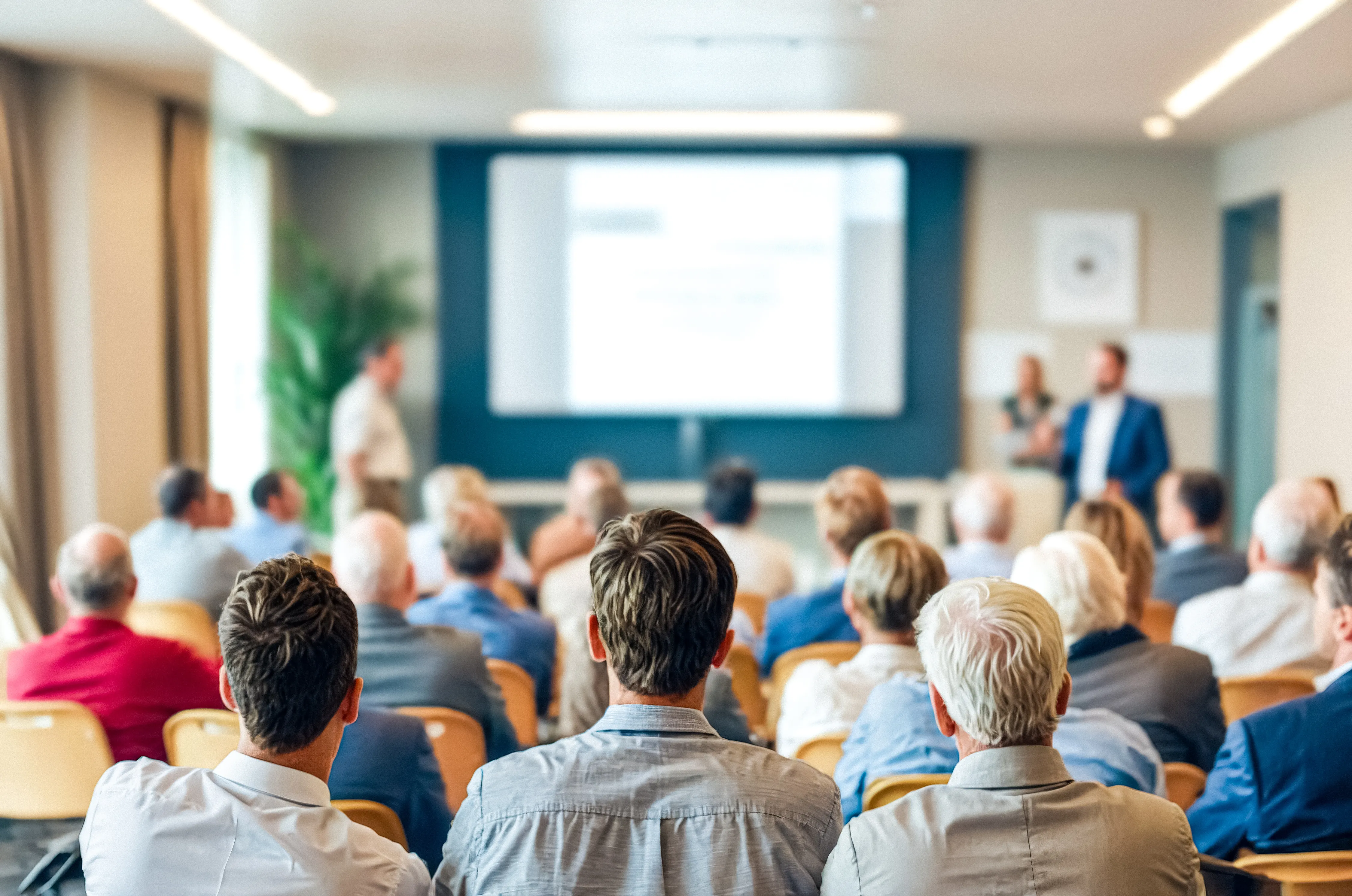 Teilnehmer einer Vortragsveranstaltung in einem Tagungsraum. 