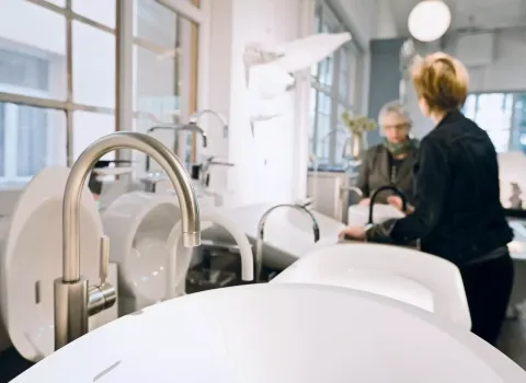 Eine moderne Ausstellung zeigt mehrere glänzende Wasserhähne und stilvolle Waschbecken in verschiedenen Designs. 