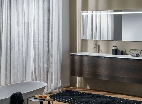 Modernes Badezimmer von Stocco mit dunklem, schwebendem Doppelwaschtisch, großem Spiegel und freistehender Badewanne.