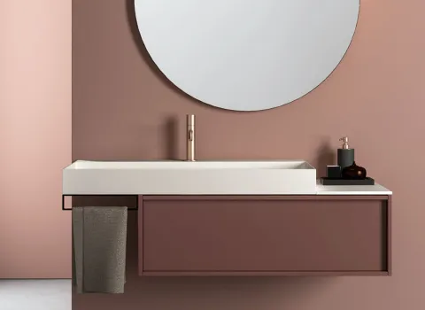 Stilvolles Badmöbel von Stocco in Altrosa mit rundem Spiegel, heller Waschtischplatte und goldfarbener Armatur.