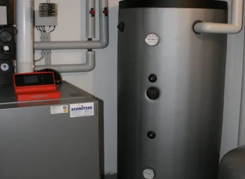 Pufferspeicher und Heizkessel mit moderner Regelungstechnik in einem Technikraum.