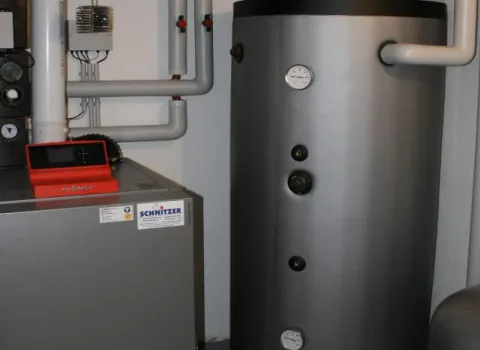 Pufferspeicher und Heizkessel mit moderner Regelungstechnik in einem Technikraum.