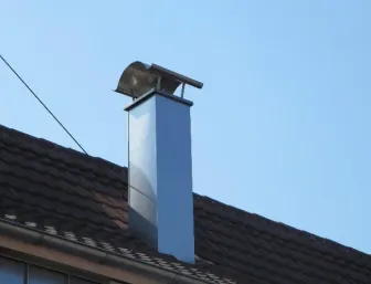 Schornsteinverkleidung aus Titanzink auf Ziegeldach.